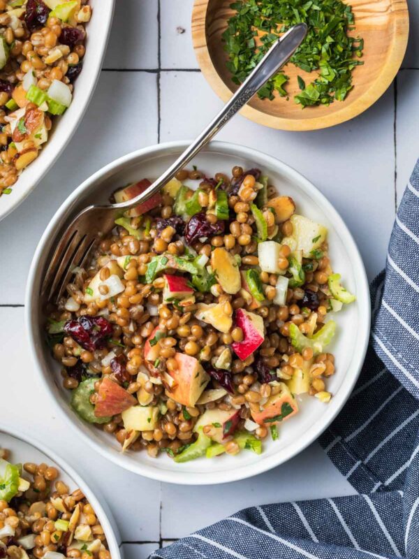 a bowl full of wheat berry salad with a fork
