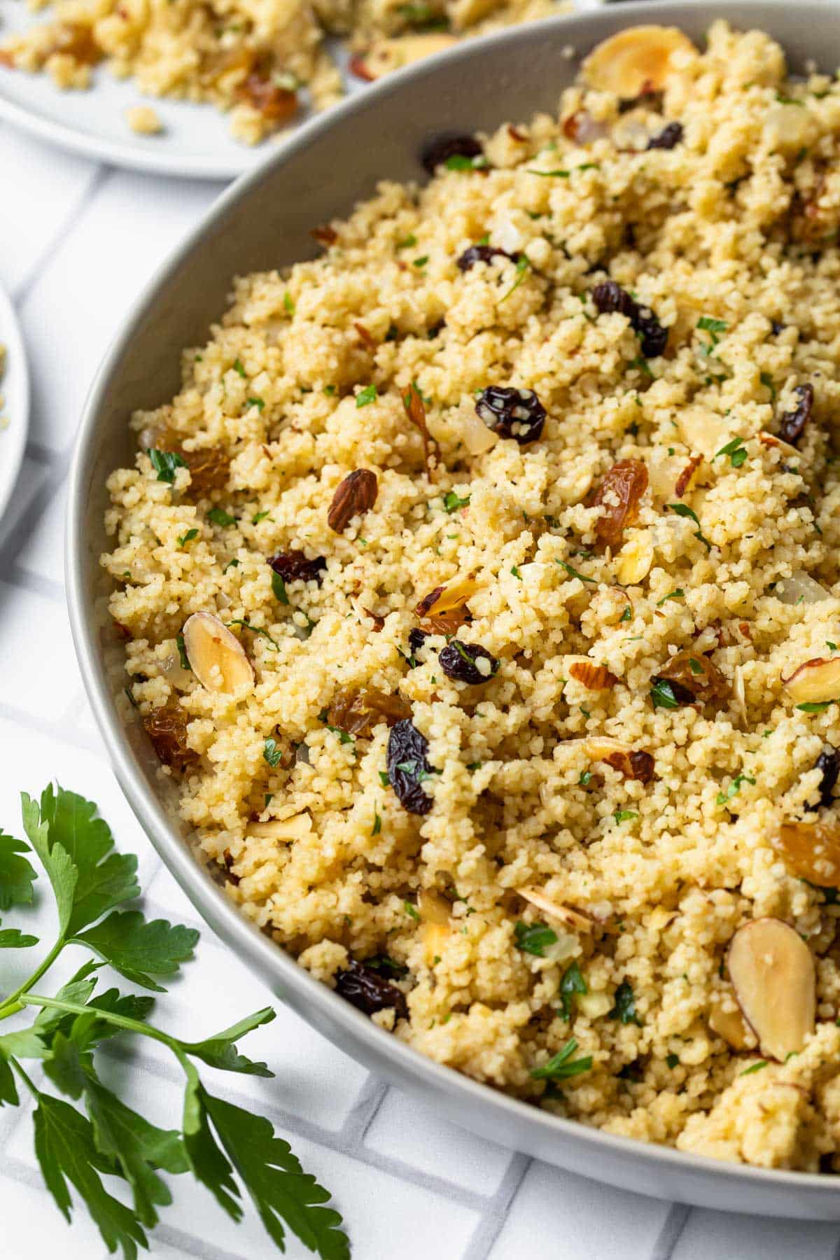 moroccan couscous with raisins and almonds in a serving dish