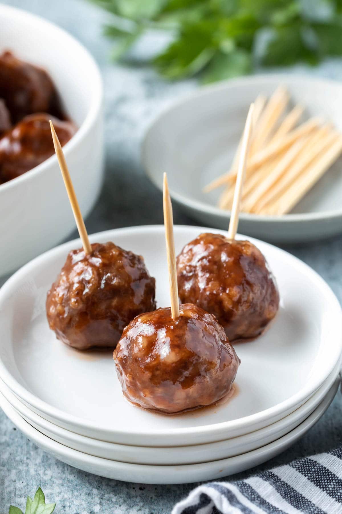 closeup of cocktail meatballs on a small plate with toothpicks in them
