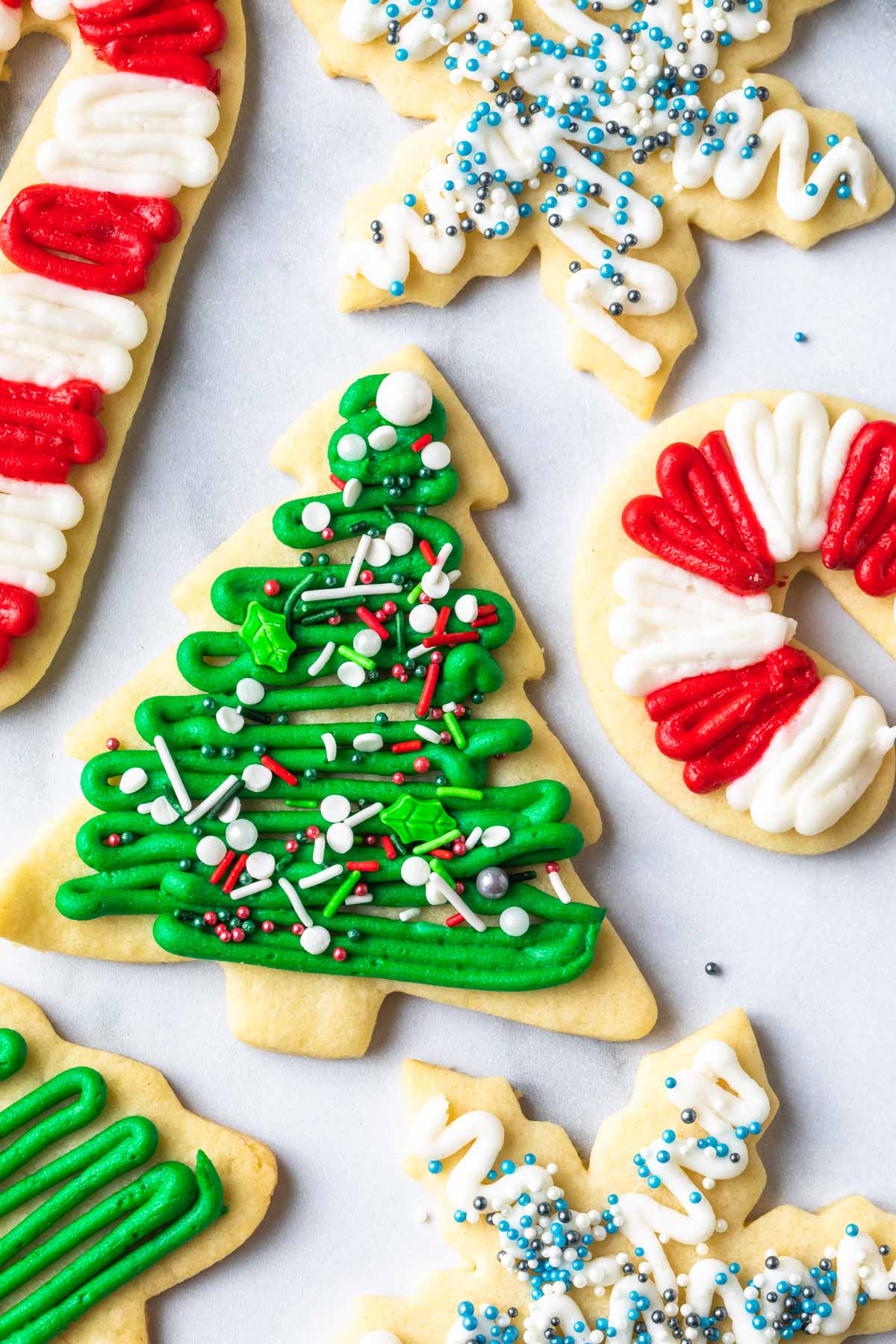 Christmas sugar cookies on a counter, christmas trees, candy canes and snowflakes 