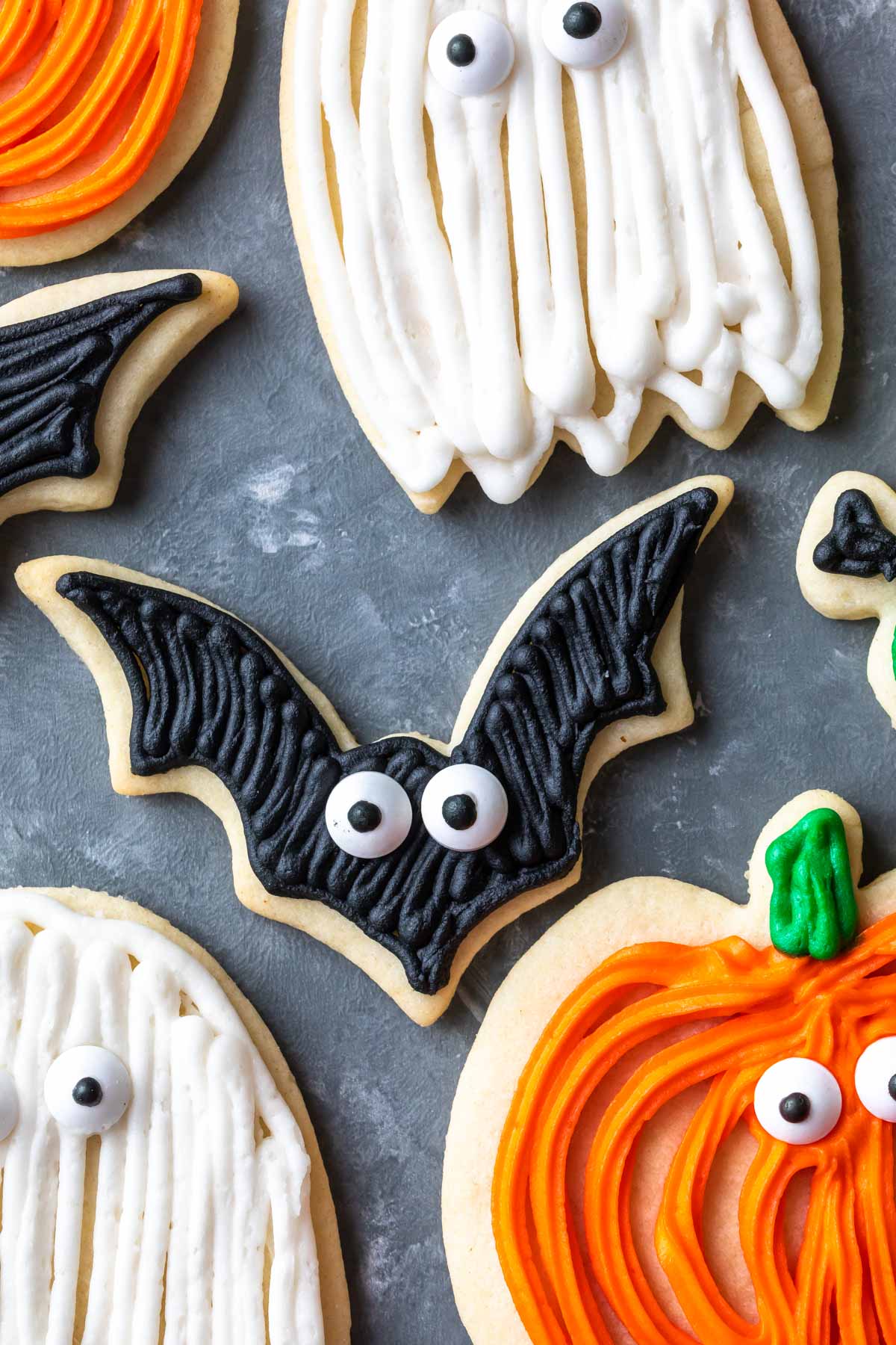 Halloween sugar cookies on a cookie sheet, pumpkins, ghosts, bats.