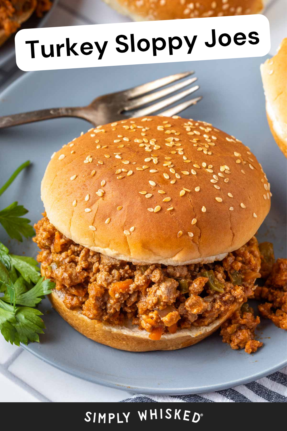 A turkey sloppy joe sandwich on a sesame seed bun sits on a plate with parsley and a fork nearby, perfectly capturing the classic comfort of homemade turkey sloppy joes. Text on the image reads Turkey Sloppy Joes and Simply Whisked.