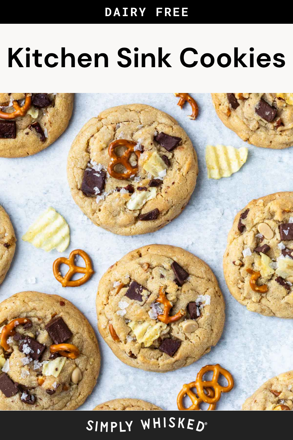 Six kitchen sink cookies with chocolate chunks, pretzels, and potato chips are arranged on a white surface. Scattered pretzel pieces and potato chips surround the cookies. The top text reads Kitchen Sink Cookies, and the bottom says Simply Whisked.