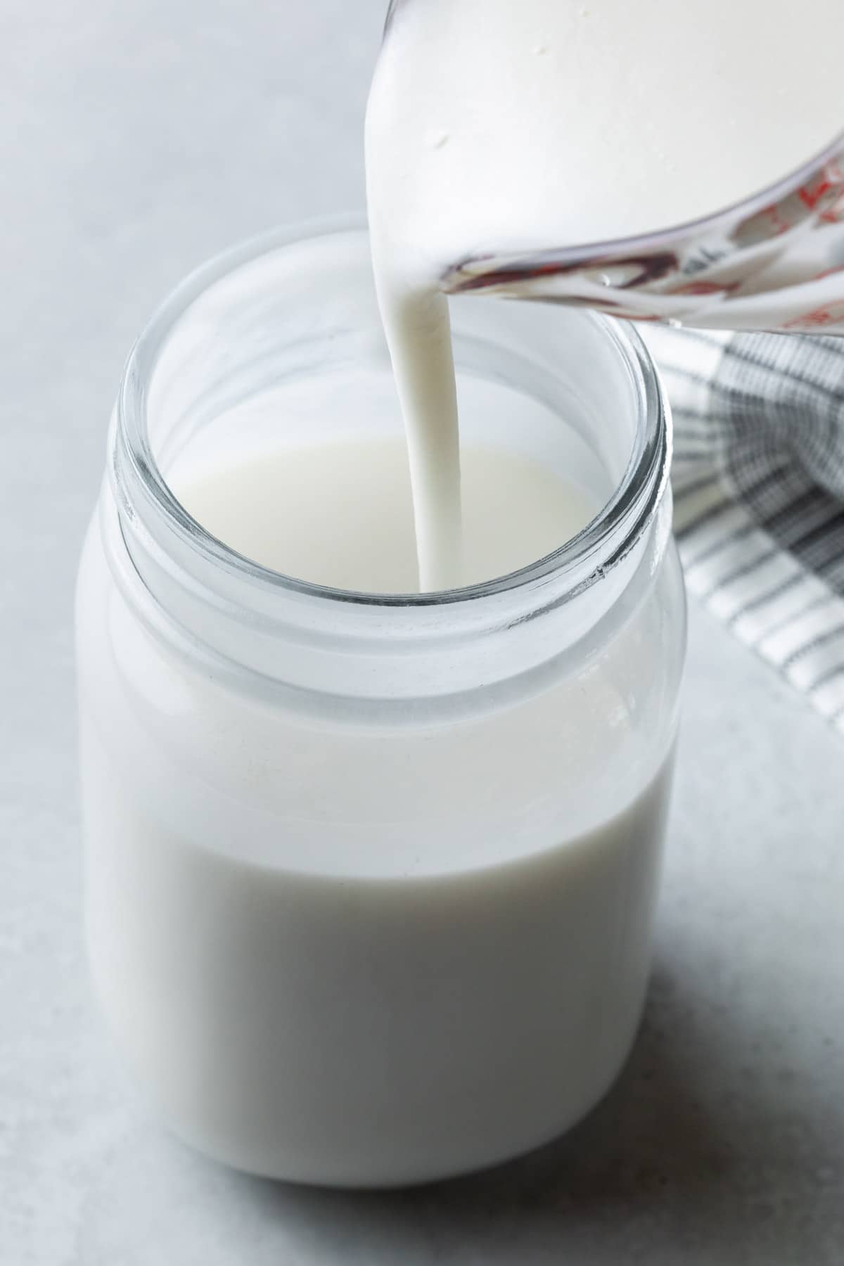 Dairy free buttermilk being poured into a mason jar from a glass pitcher