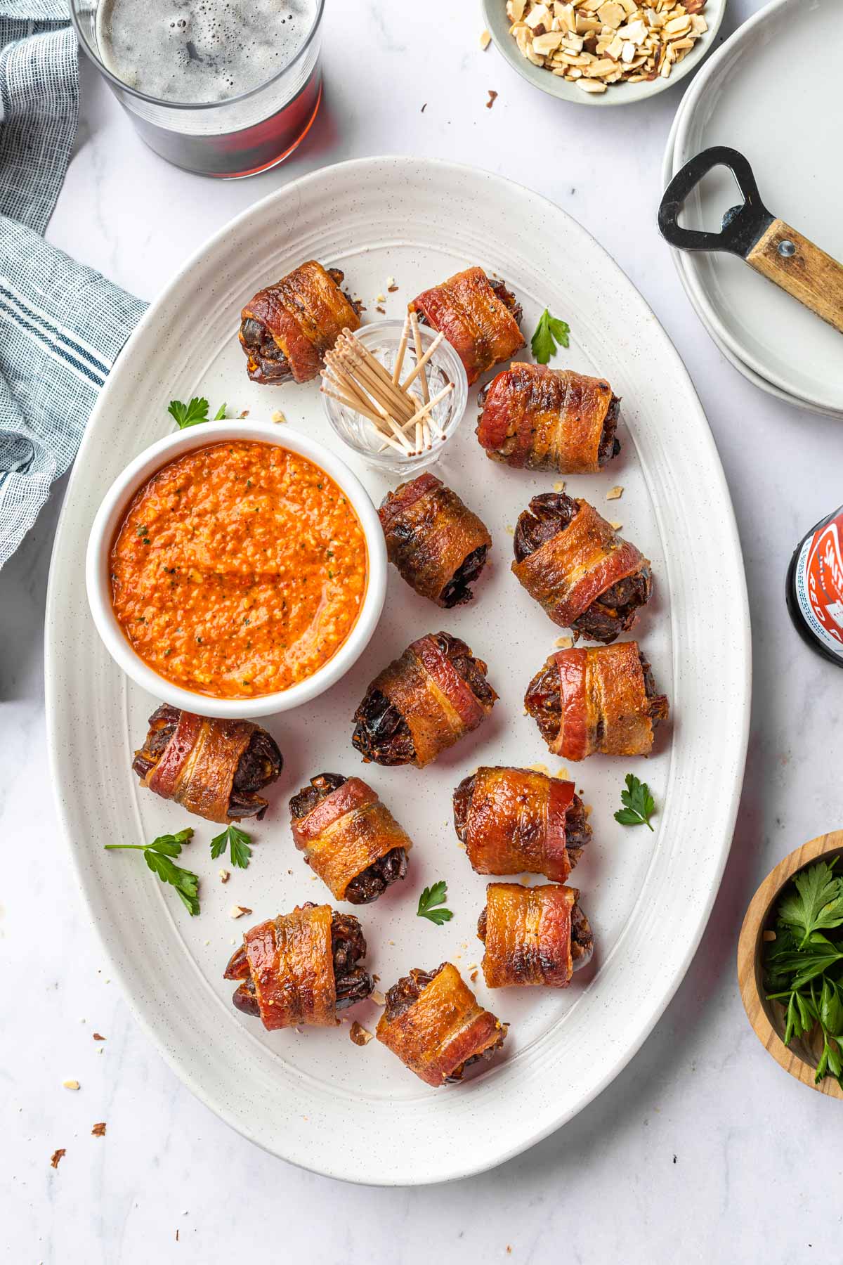 An overhead shot chorizo stuffed, bacon wrapped dates on a serving platter. 