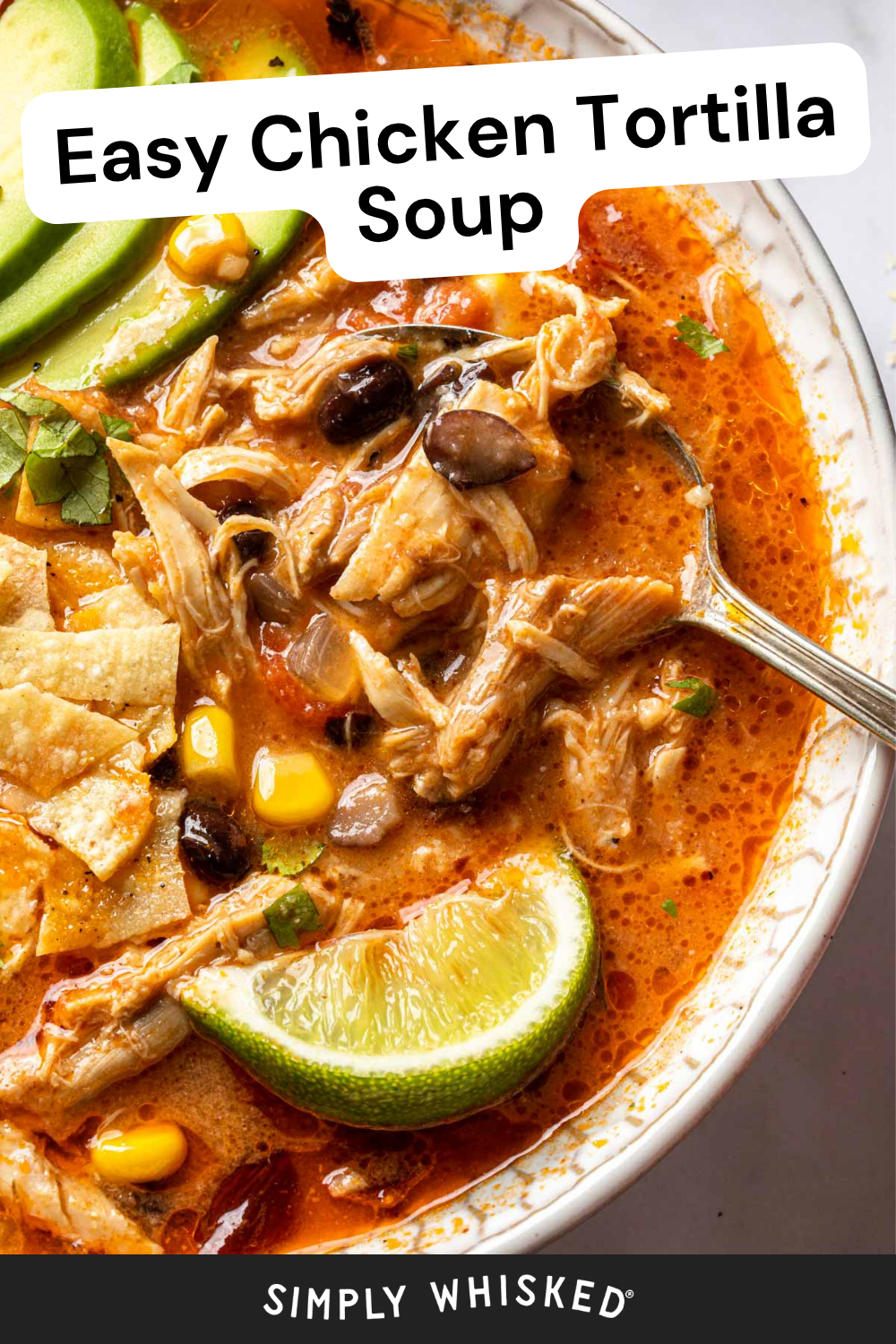 Bowl of chicken tortilla soup with shredded chicken, black beans, corn, tortilla chips, avocado slices, lime wedge, and a spoon. Text reads Easy Chicken Tortilla Soup. This comforting chicken tortilla soup is loaded with fresh ingredients and perfect for a cozy meal.