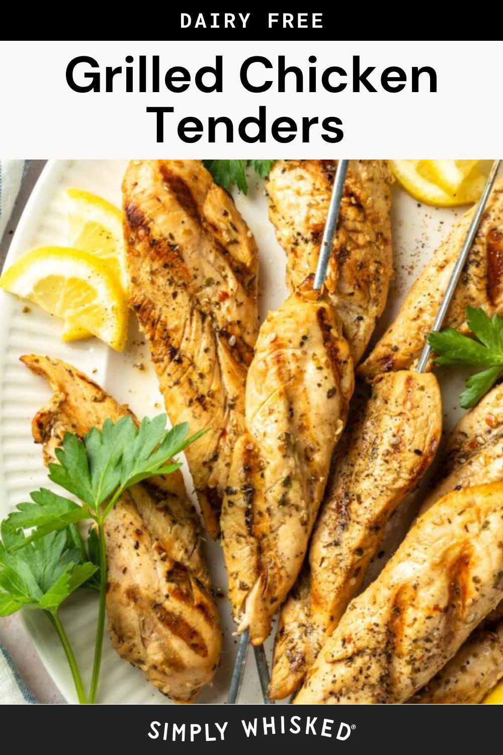 Grilled chicken tenders on skewers are served on a white plate with lemon wedges and fresh parsley, highlighting these delicious grilled chicken tenders as a dairy-free option.