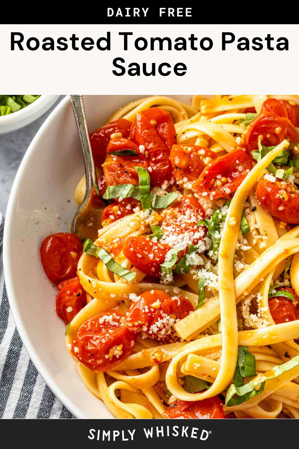 A bowl of pasta topped with roasted tomatoes, fresh basil, and grated cheese, finished with a generous spoonful of Roasted Tomato Pasta Sauce, with a fork and a striped napkin nearby.