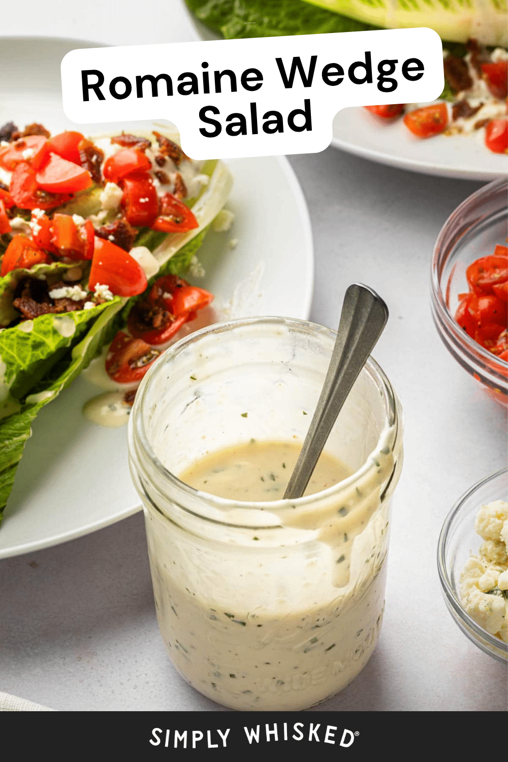 A jar of creamy dressing with a spoon sits in front of a plate with romaine wedge salad, topped with tomatoes and cheese. Text at top reads Romaine Wedge Salad, making it the perfect inspiration for your next wedge salad recipe.