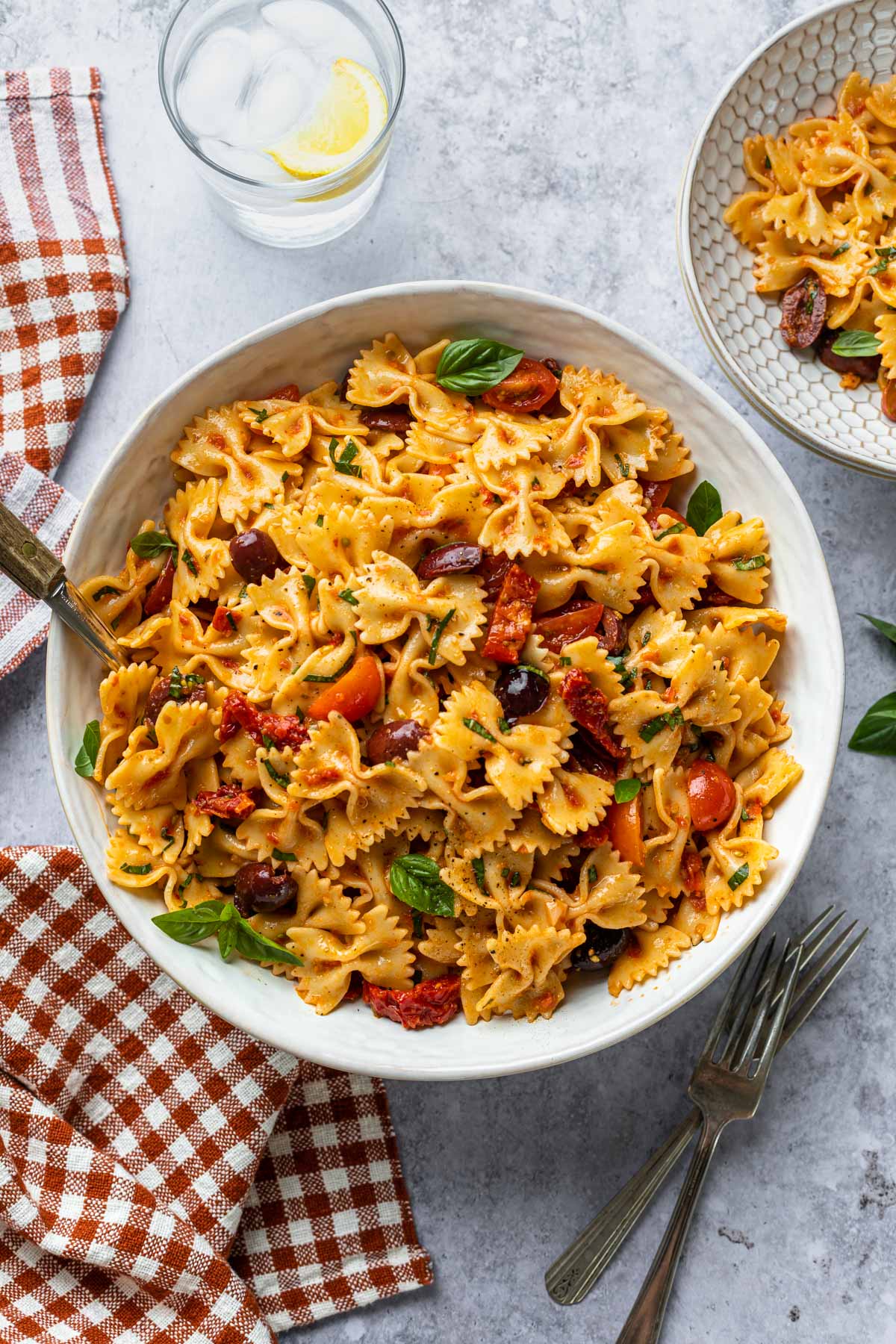 A serving bowl full of sun dried tomato pasta salad. 