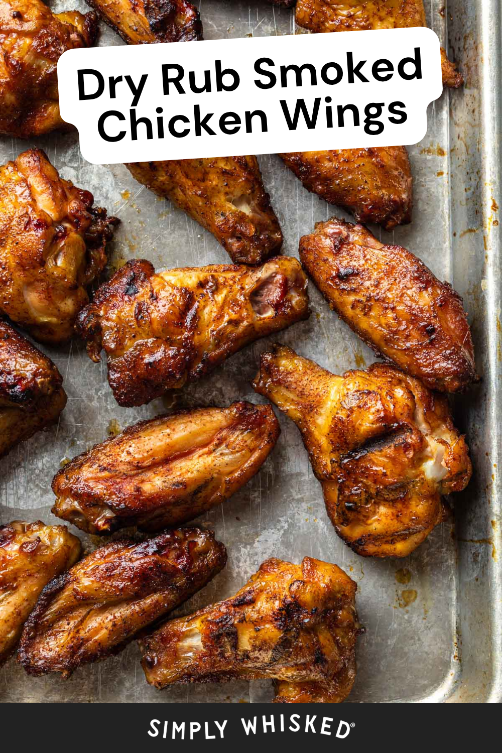 A baking tray filled with several smoked chicken wings, golden brown and crispy from a flavorful dry rub. Text reads: “Dry Rub Smoked Chicken Wings” and “Simply Whisked.”.