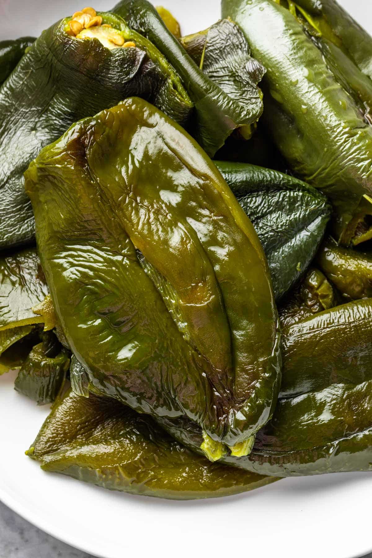 Close up of cooked poblano peppers in a bowl, with the skins removed. 