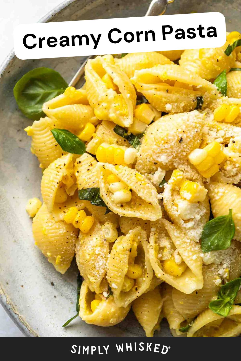 A plate of delicious corn pasta features shell pasta mixed with corn kernels, fresh basil leaves, and grated cheese, labeled Creamy Corn Pasta at the top and Simply Whisked at the bottom.