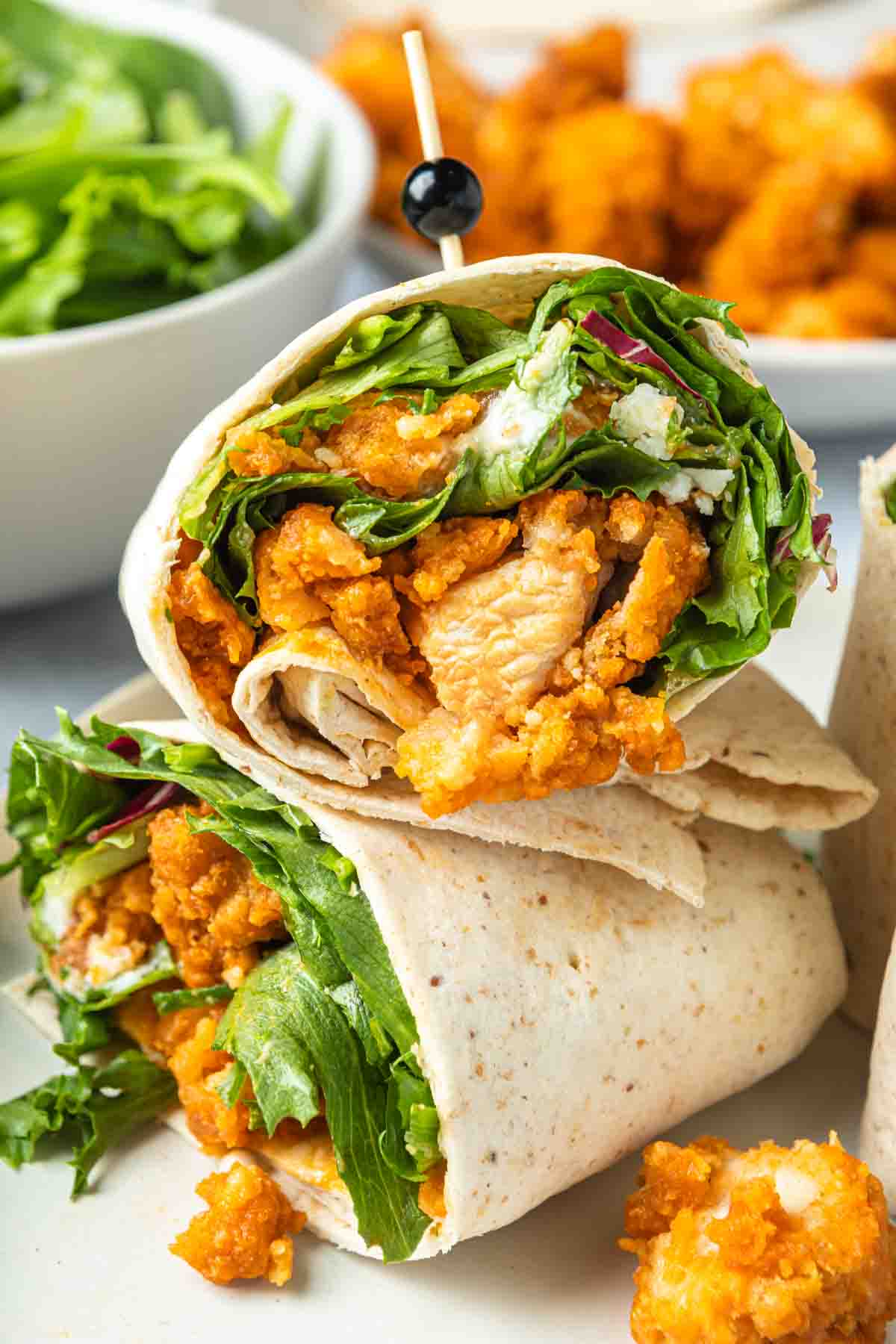 Close up of a buffalo chicken wrap with a toothpick through it. 