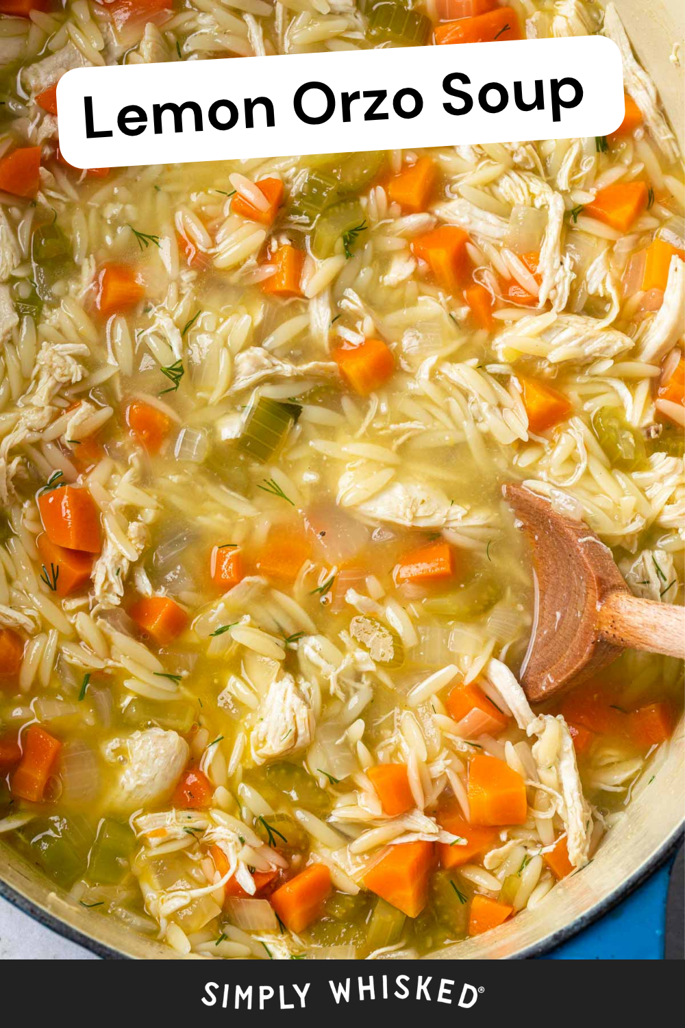 A pot of Lemon Orzo Soup with shredded chicken, carrots, celery, and fresh dill being stirred with a wooden spoon.
