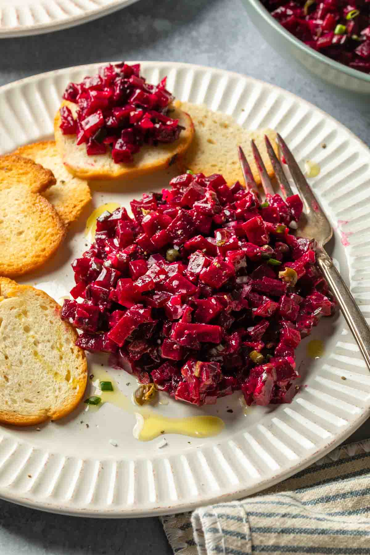 A plate with beet tartare drizzled with olive oil. 