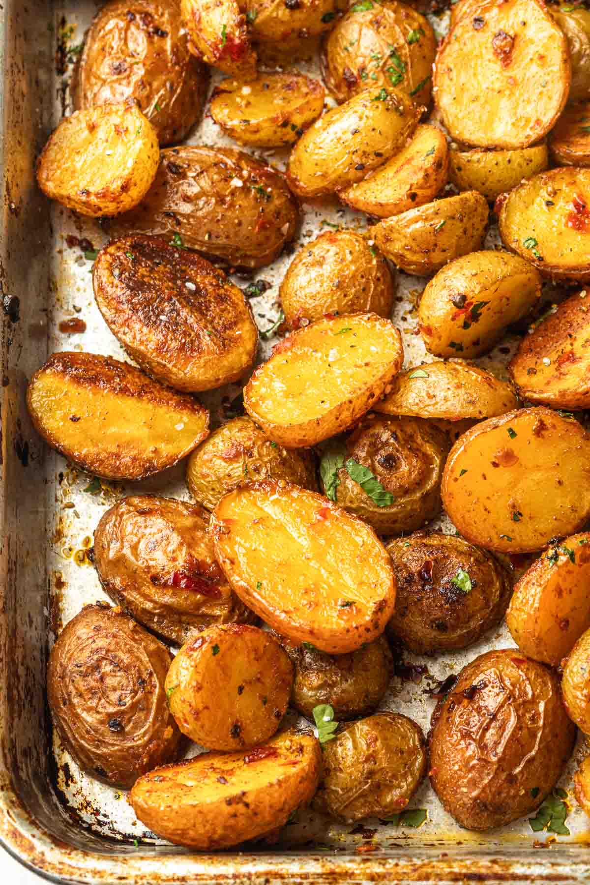 Close up of roasted duck fat potatoes on a baking sheet.