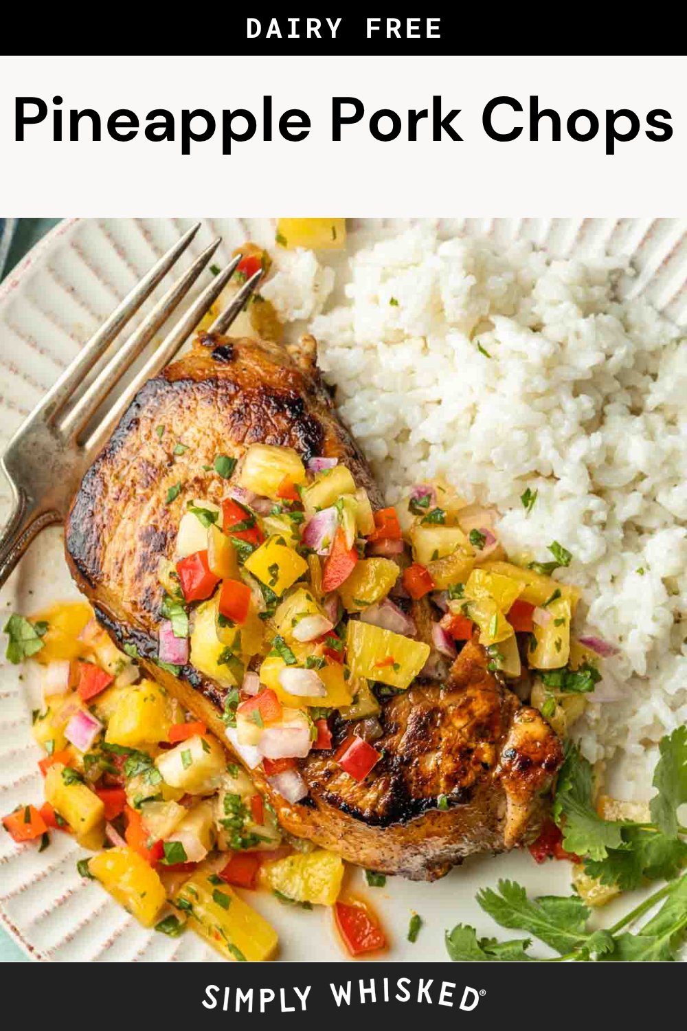 A grilled pork chop topped with pineapple salsa is served next to white rice and garnished with fresh herbs. This Pineapple Pork Chops dish is dairy free and perfect for a flavorful, tropical-inspired meal.
