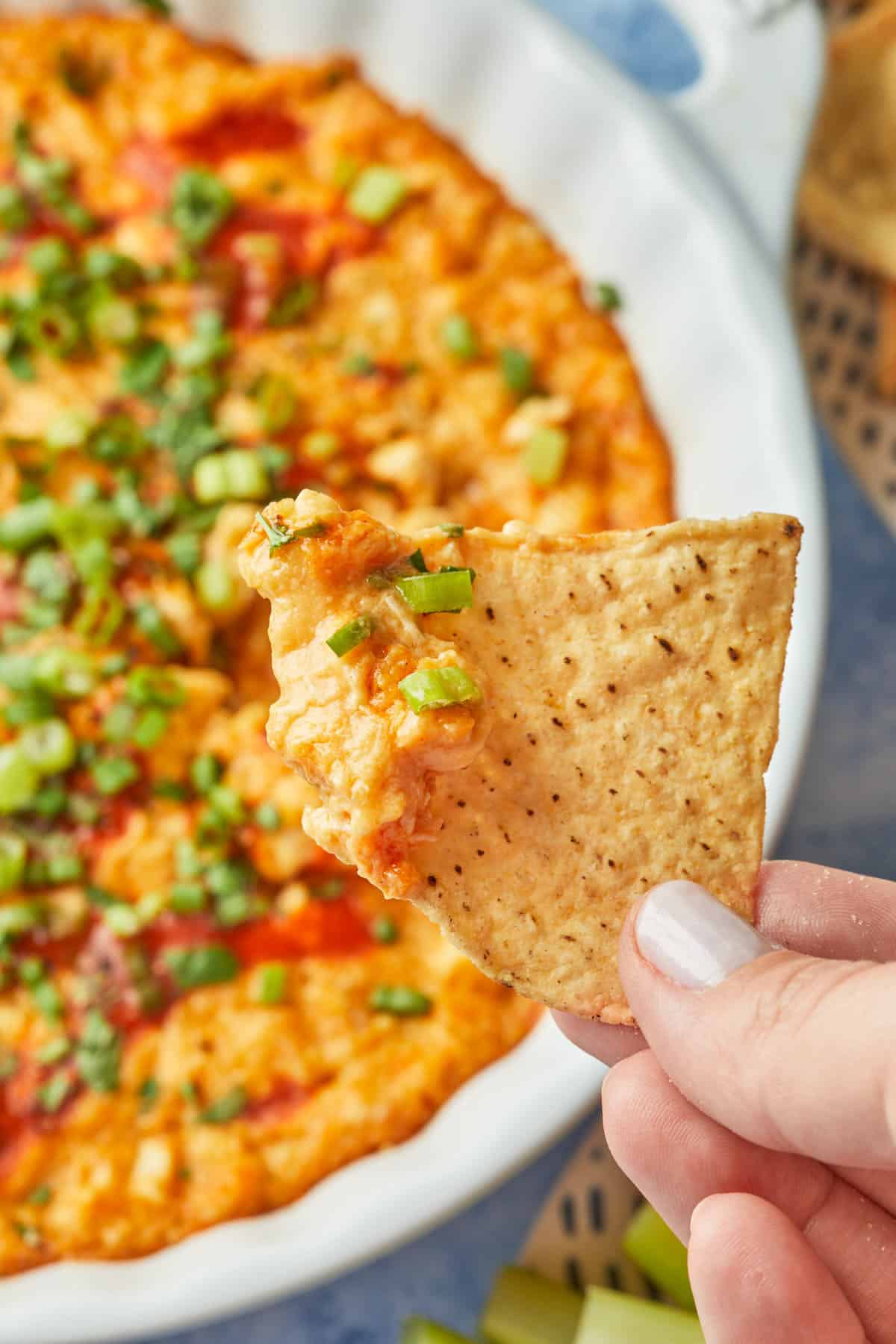 A tortilla chip dipped in a spicy dip, made to taste like hot wings. 