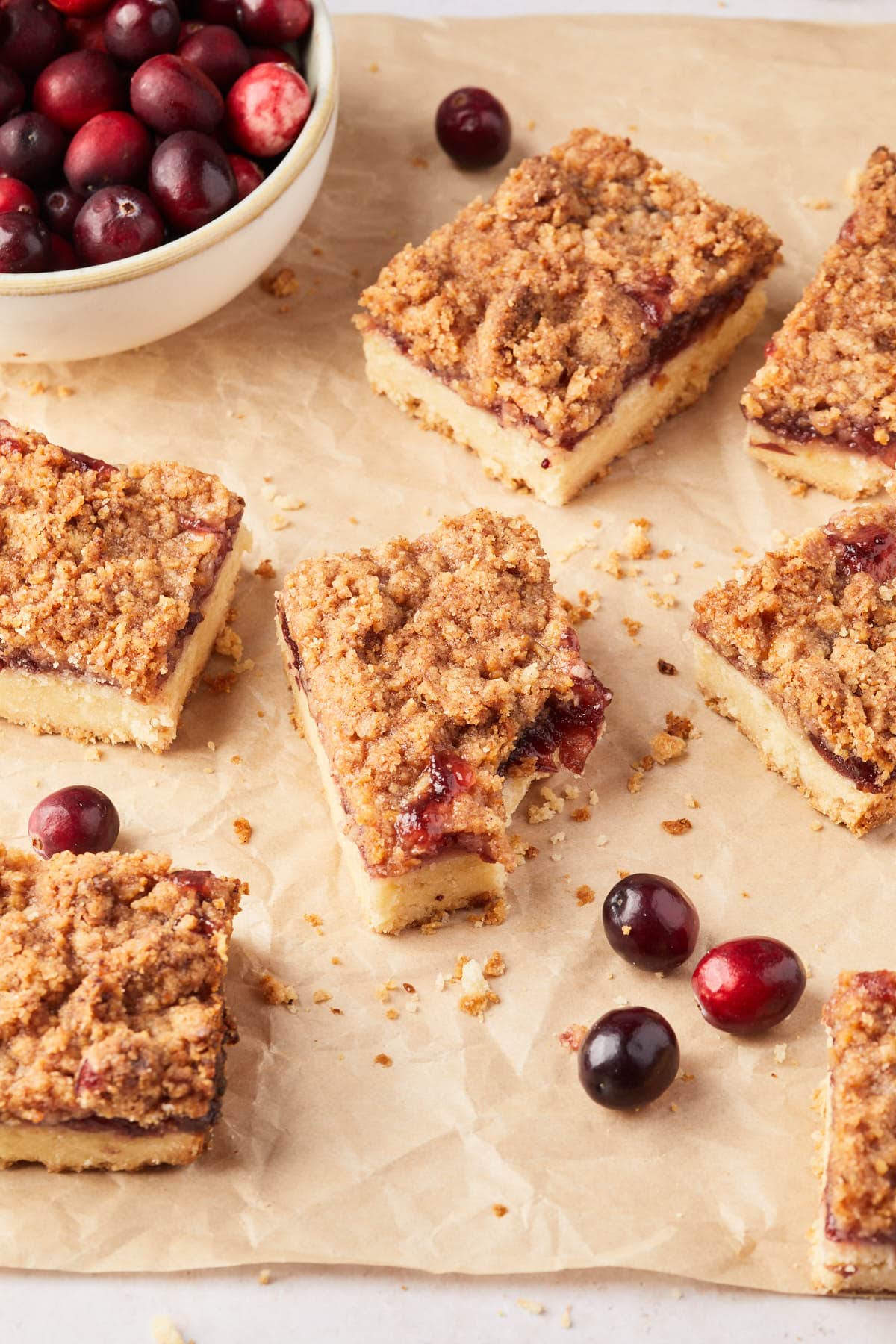 Shortbread fruit pastries on parchment paper, one with a bit taken out of it. 