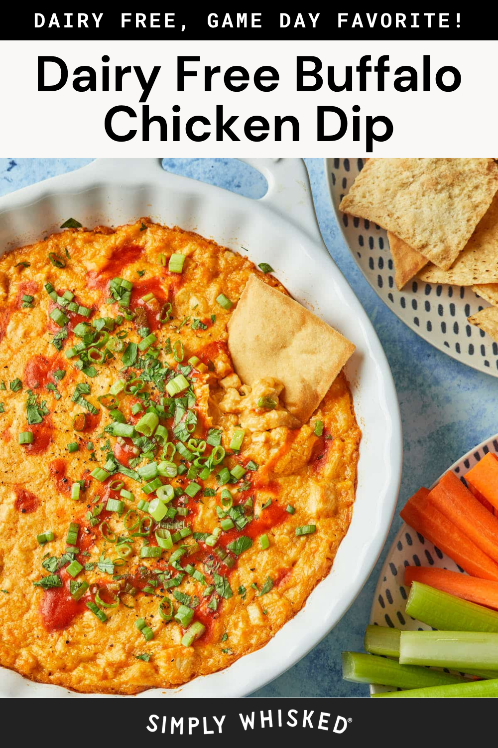A white dish of Healthy Buffalo Chicken Dip, completely dairy-free and topped with chopped green onions, is served alongside pita chips and fresh carrot and celery sticks for the perfect wholesome snack.