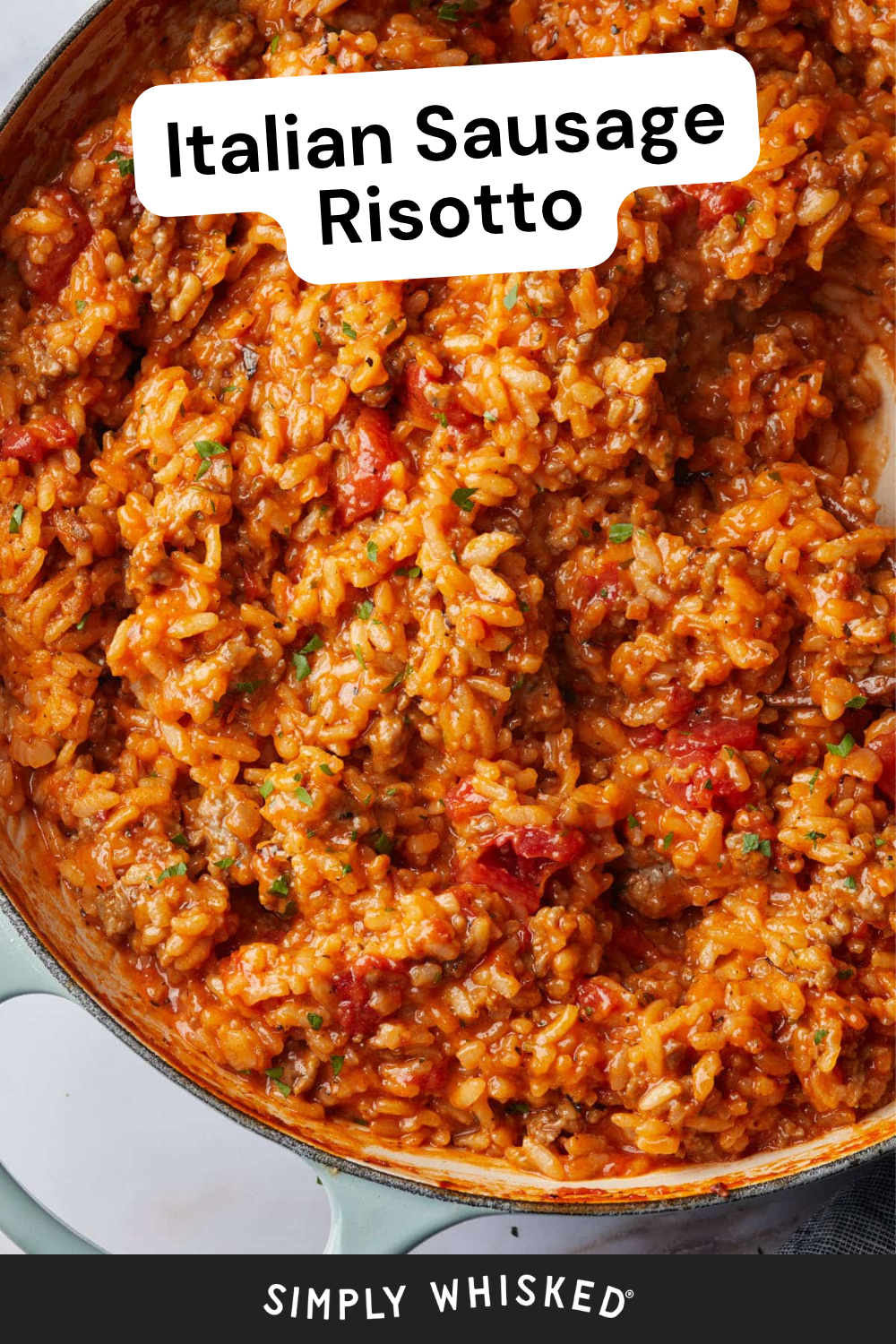 Close-up of creamy sausage risotto in a pan, featuring rice, sausage, tomato, and herbs. White label says Italian Sausage Risotto. Bottom text reads Simply Whisked.