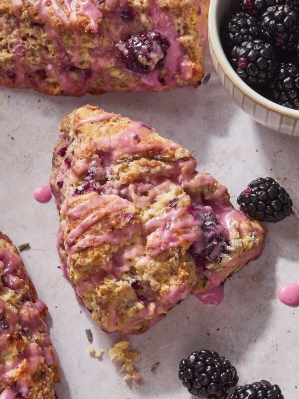 Close up of a few lavender blackberry scones glazed with a purple glaze.
