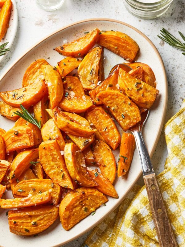 A serving platter of gold root vegetables, roasted with honey and rosemary.