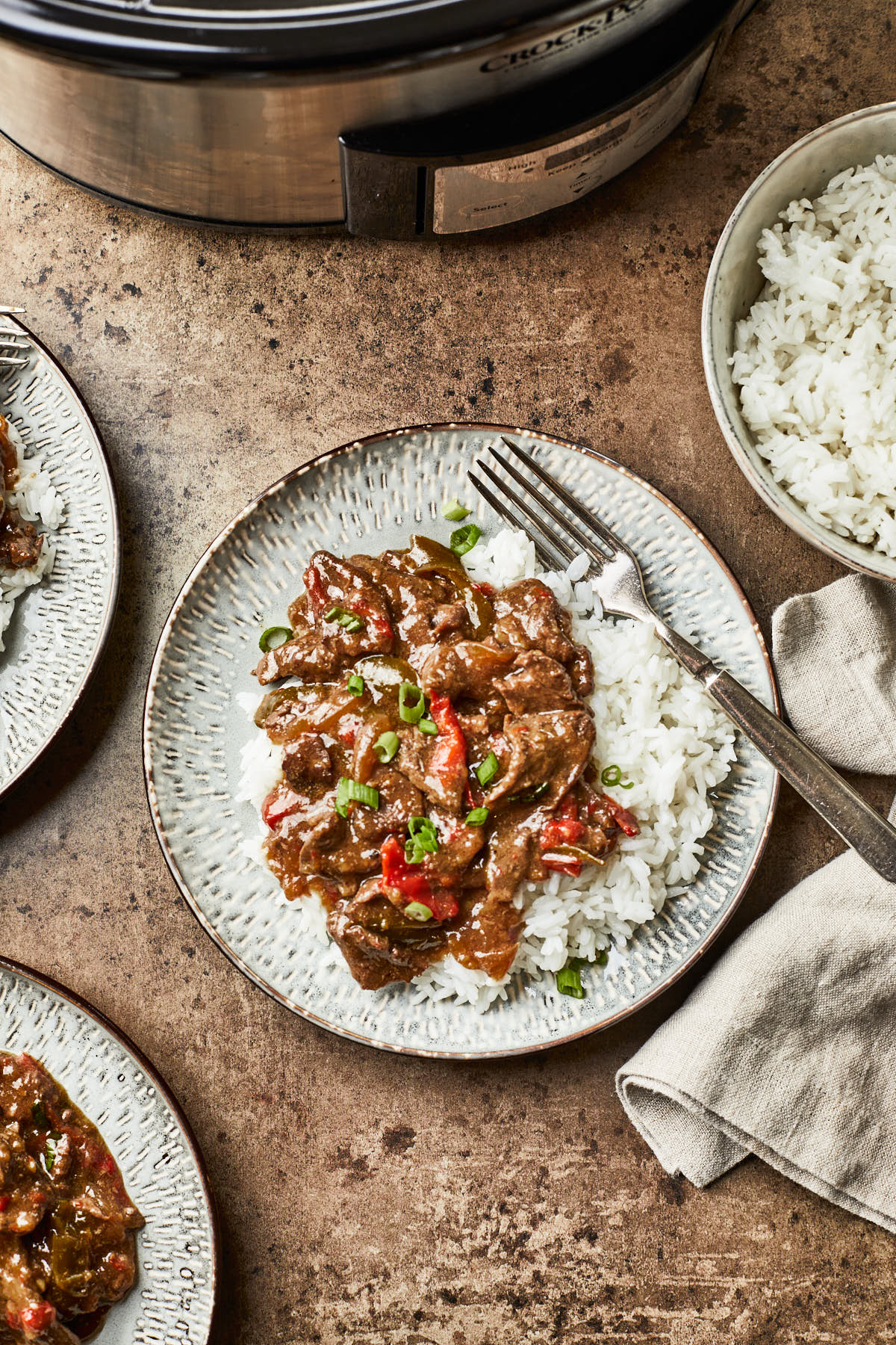 Overhead photo of a crock pot beef dish served with white rice. 