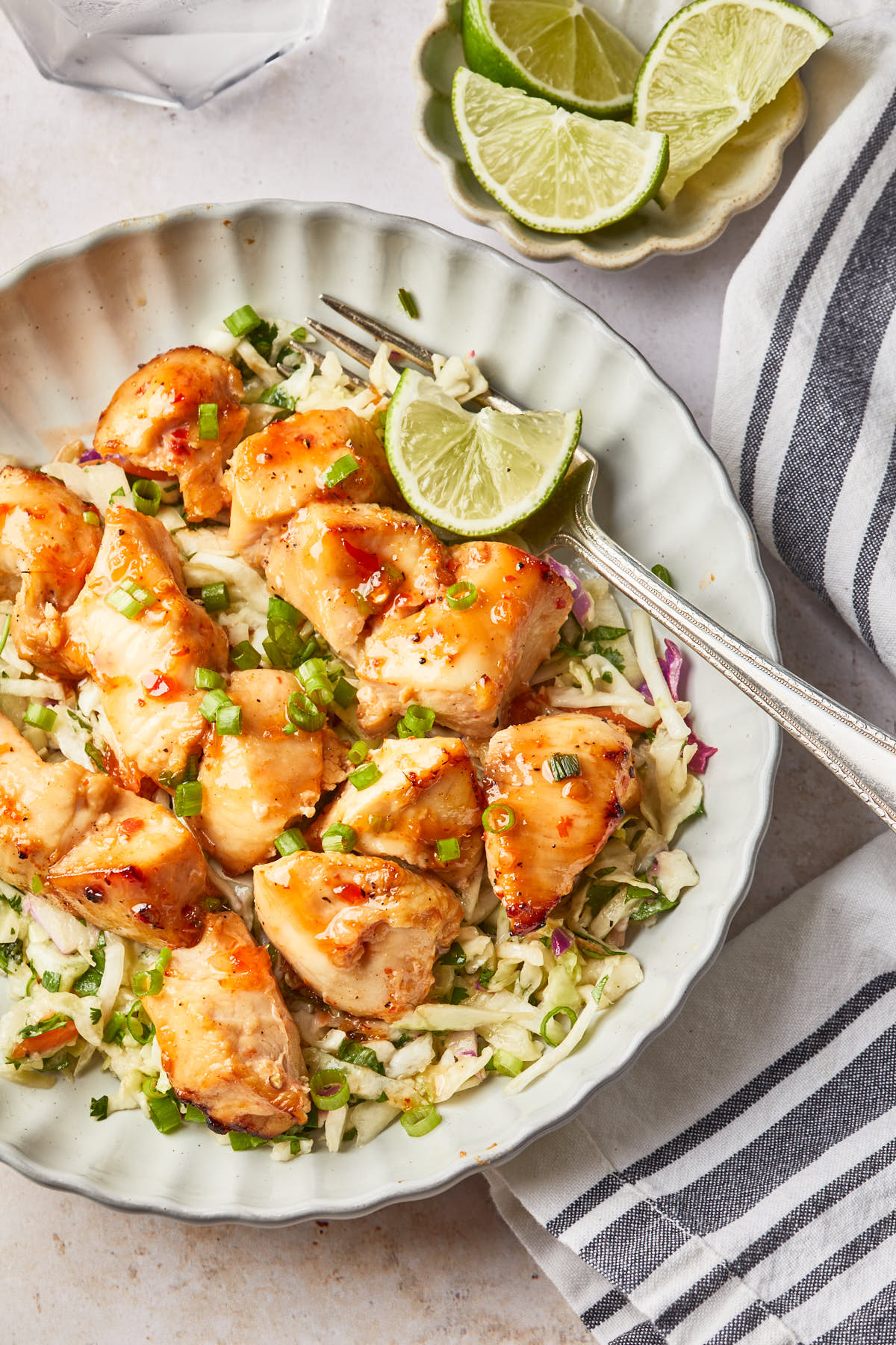 Close up of grilled chicken bites in a sweet chili sauce. 