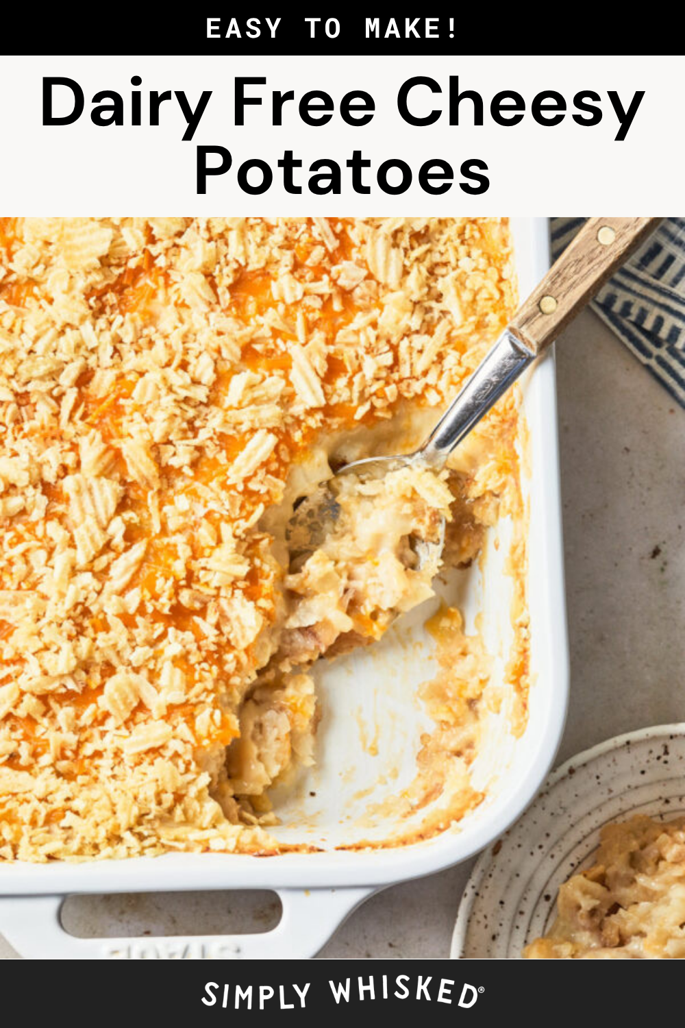 Casserole dish filled with dairy free Cheesy Potatoes topped with crushed crackers, a serving spoon inside, and a small portion of the Cheesy Potatoes served on a plate nearby.