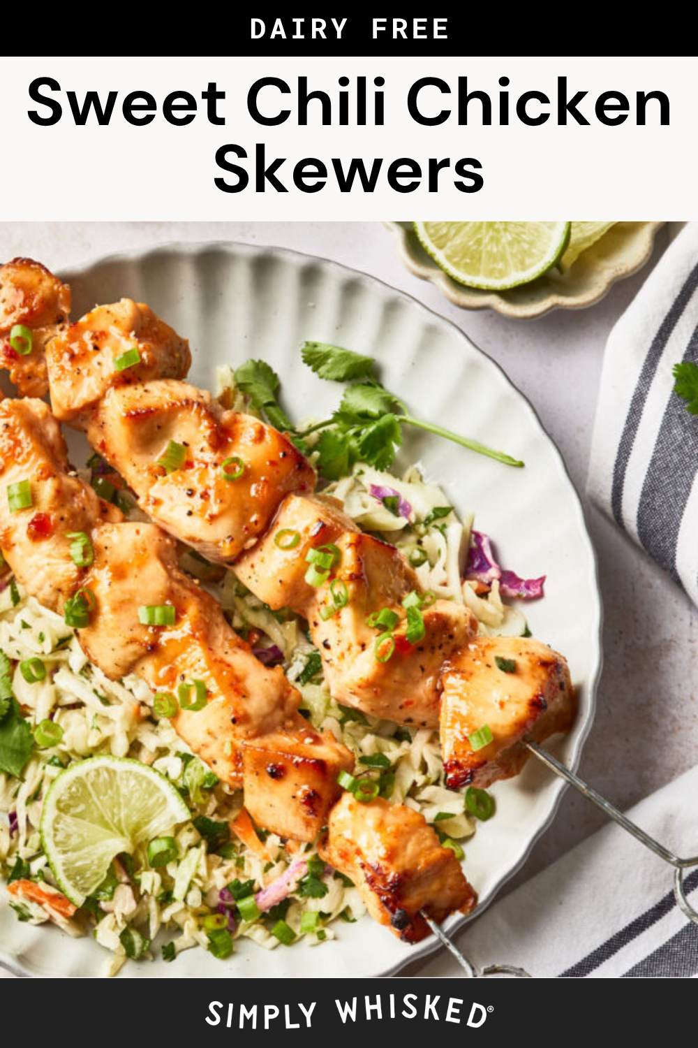 Two Sweet Chili Chicken skewers are coated in sweet chili sauce and served over rice with chopped green onions, cilantro, and lime wedges on a white plate. A striped napkin and extra lime slices complete this vibrant dish.