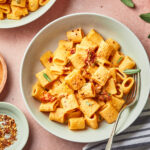 creamy pumpkin rigatoni with sun dried tomatoes garnished with sage
