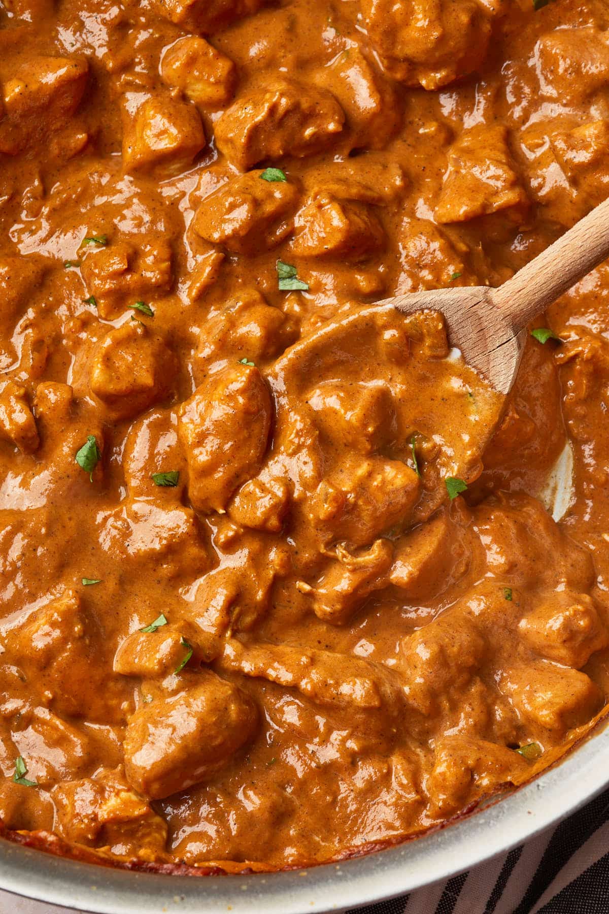 Close up of butter chicken in a dutch oven showing the creamy and thick sauce.