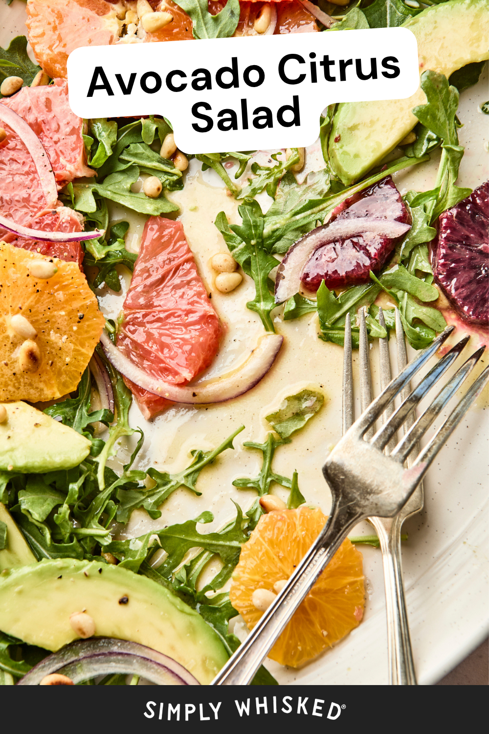 A plate of avocado citrus salad with arugula, citrus slices, avocado, red onion, pine nuts, and dressing. A fork rests on the plate. Text reads Avocado Citrus Salad and Simply Whisked, highlighting the fresh and vibrant flavors of this irresistible avocado citrus salad.