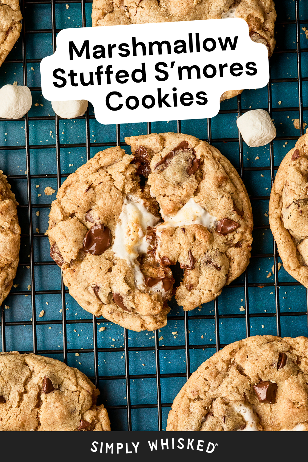 Close-up of gooey s’mores cookies, stuffed with melted marshmallow and chocolate chips, displayed on a cooling rack. Text at the top reads “Marshmallow Stuffed S’mores Cookies.”.