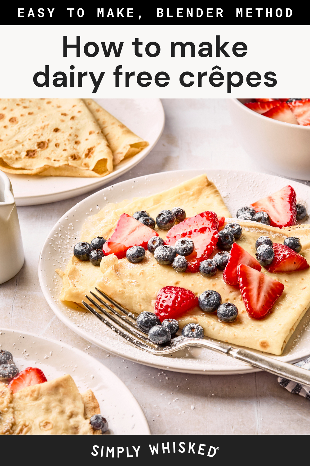 A plate of fluffy dairy free crepes topped with fresh strawberries, blueberries, and powdered sugar, with a fork on the plate. More crepes and fruit sit nearby. Text above reads How to make dairy free crêpes.
