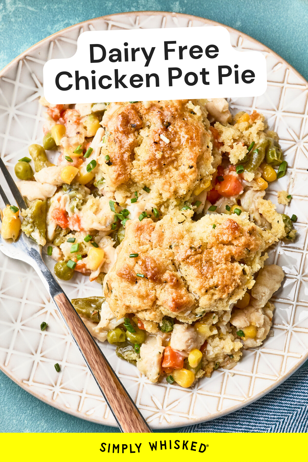 A plate with a serving of easy chicken pot pie with biscuits, featuring chunks of chicken, mixed vegetables, and a golden biscuit topping, sits beside a fork on a patterned plate. Text reads “Dairy Free Chicken Pot Pie.”.