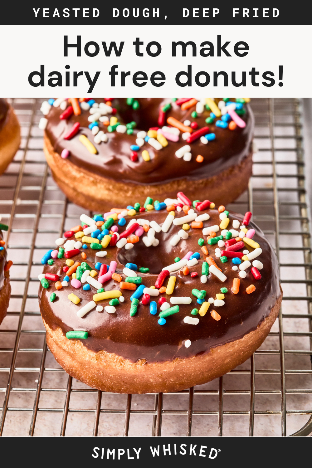Close-up of chocolate-glazed dairy free donuts topped with colorful sprinkles on a cooling rack. Text above reads, How to make dairy free donuts! Yeasted dough, deep fried, with Simply Whisked at the bottom.