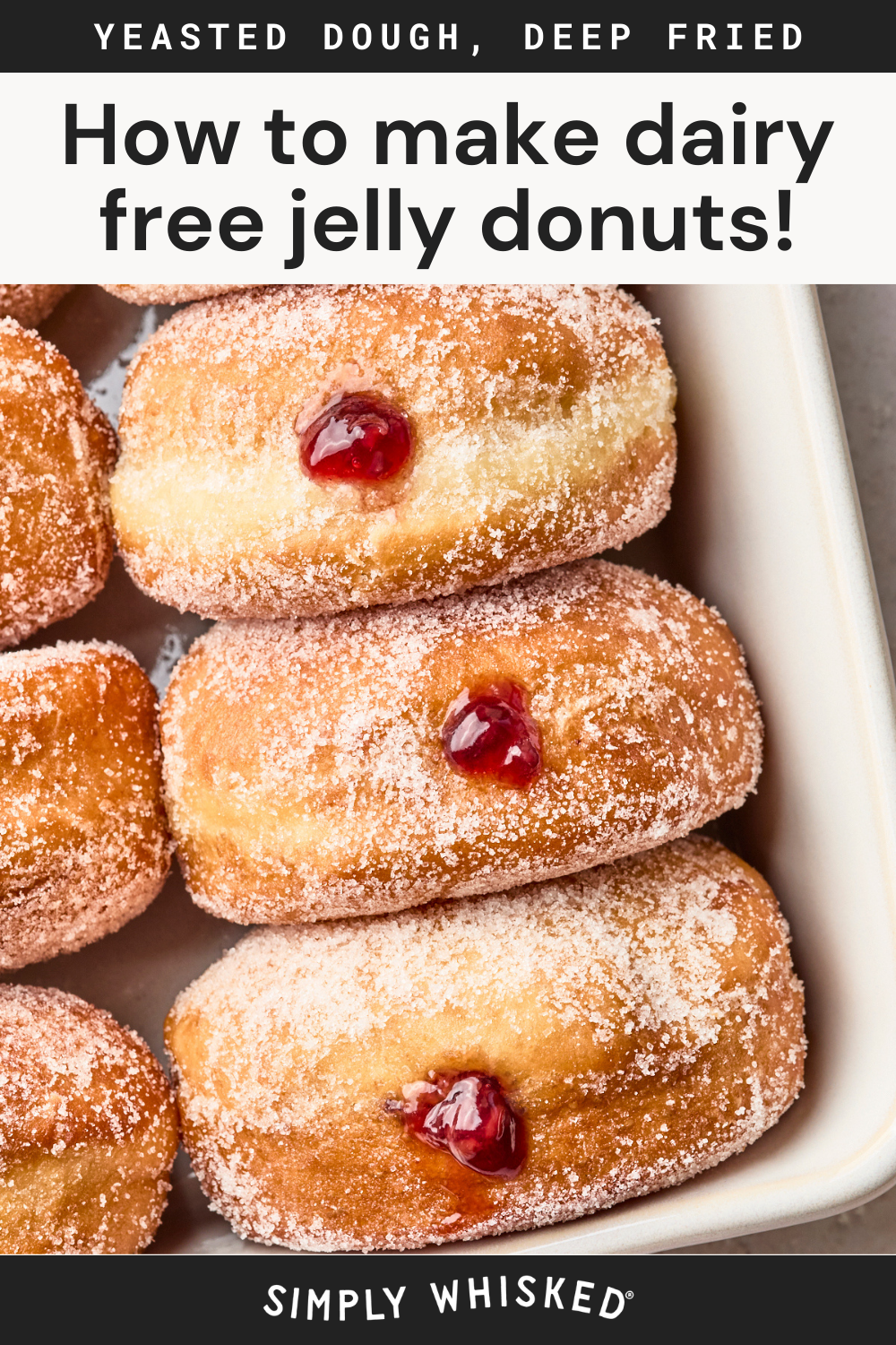 Close-up of sugar-coated jelly donuts arranged in a dish, each filled with red jelly. Text at the top reads, How to make dairy free jelly donuts! and YEASTED DOUGH, DEEP FRIED.