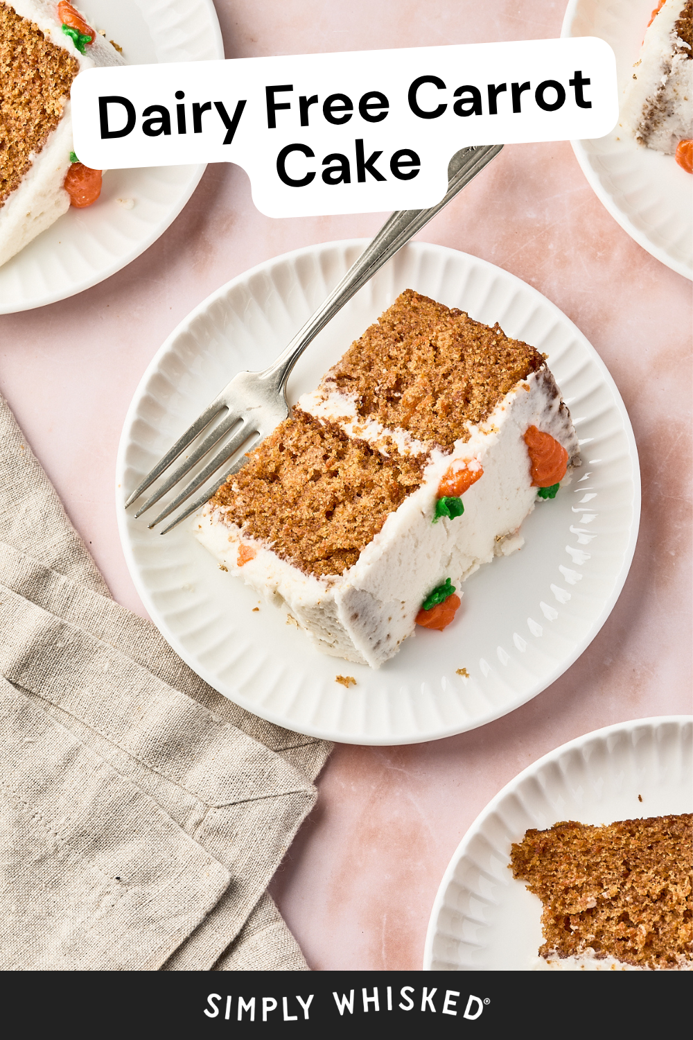 A slice of dairy free carrot cake with white frosting and carrot decorations sits on a white plate next to a fork, with more slices of this delicious dairy free carrot cake on side plates.