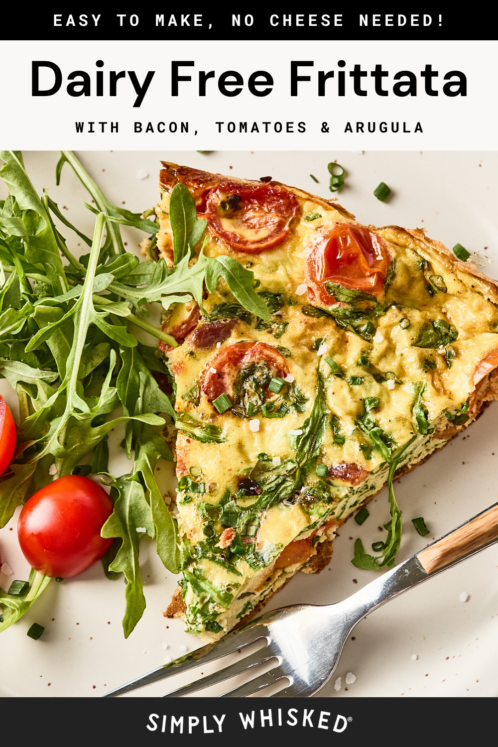 A slice of dairy-free frittata with bacon, tomatoes, and arugula is served on a plate. Fresh arugula and cherry tomatoes are on the side, with a fork visible next to the frittata.
